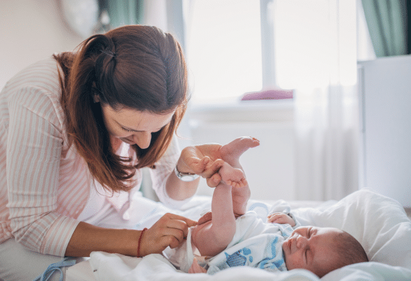 parent changeant la couche de bébé et observant la couleur des selles