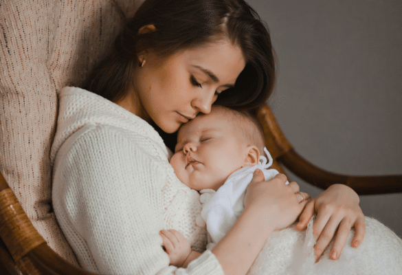 Maman tenant son bébé fatigué dans ses bras pendant une gastro bébé