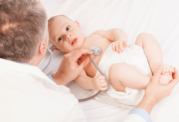 Médecin qui ausculte un bébé allongé avec un stéthoscope pour vérifier sa respiration et sa toux.