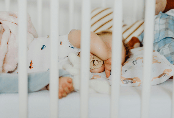 Bébé éveillé dans son lit, observant autour de lui, illustrant les réveils nocturnes normaux du nourrisson.