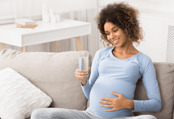 Femme enceinte buvant un verre d'eau pendant la grossesse