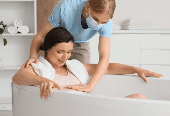 femme enceinte en position accroupie dans une baignoire d’accouchement pendant le travail actif