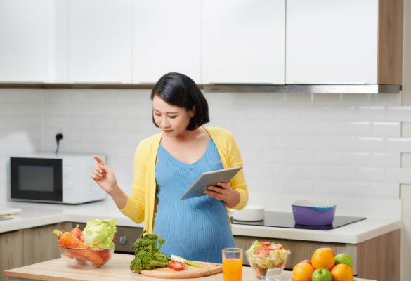 Femme enceinte préparant un repas équilibré pendant la grossesse