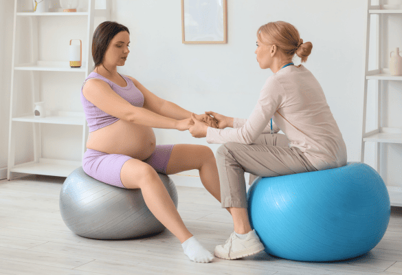 future maman assise sur un ballon de naissance accompagnée par une sage-femme pendant le travail