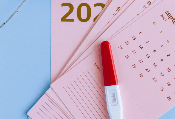 test de grossesse posé sur un calendrier pour calculer la date d’accouchement
