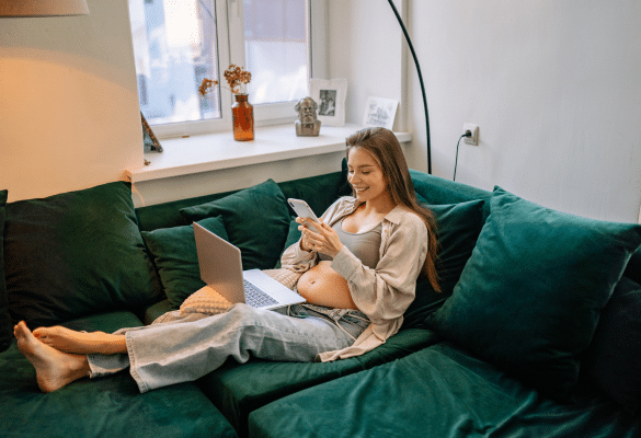 emme enceinte utilisant un calculateur de grossesse sur ordinateur pour estimer sa date d’accouchement