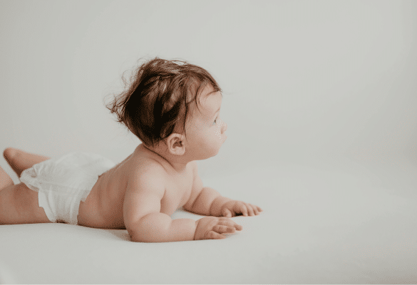 Bébé allongé dans une pièce claire et aérée, habillé légèrement pendant les fortes chaleurs