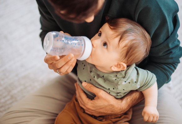 Parent donnant un biberon à son bébé pour l’hydrater lors des fortes chaleurs