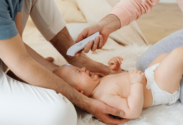 Parent prenant la température de son bébé pour surveiller une diarrhée bébé
