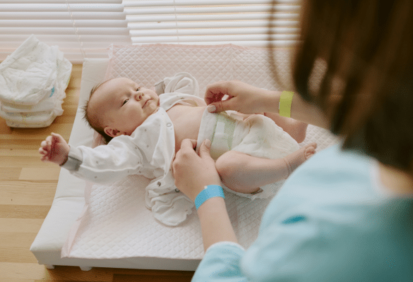 Parent changeant son bébé et surveillant une diarrhée bébé à domicile