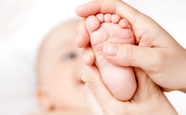 parent examinant les pieds d’un bébé pour vérifier une éruption cutanée pied main bouche