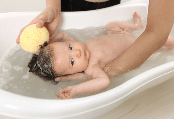 Bébé dans un bain chaud dans une ambiance calme pour favoriser l’apaisement
