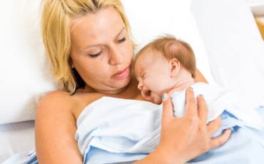 Parent berçant son bébé contre lui pour favoriser l’apaisement