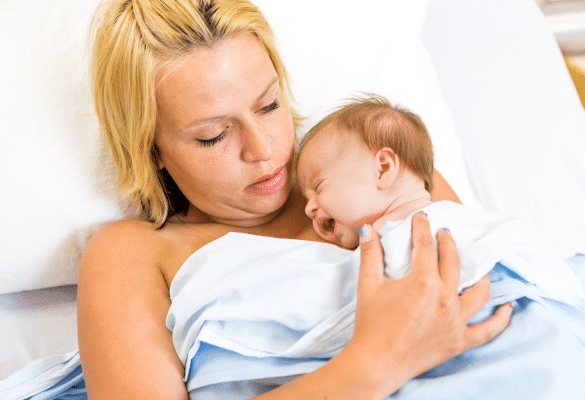 Parent berçant son bébé contre lui pour favoriser l’apaisement