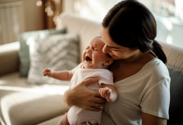 Parent tenant un bébé en pleurs contre lui pour le calmer