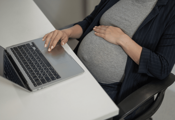 femme enceinte utilisant un ordinateur pour préparer son congé maternité