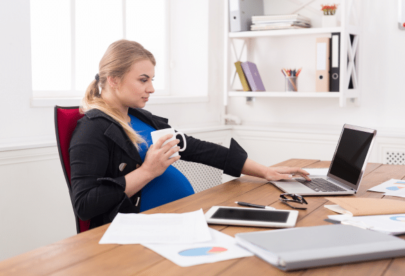femme enceinte fatiguée au travail illustrant le besoin d’adapter le congé maternité