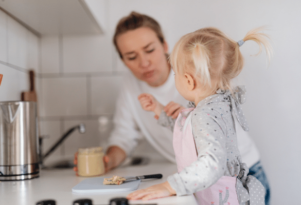 Enfant participant à un atelier cuisine avec un adulte dans une activité petite enfance