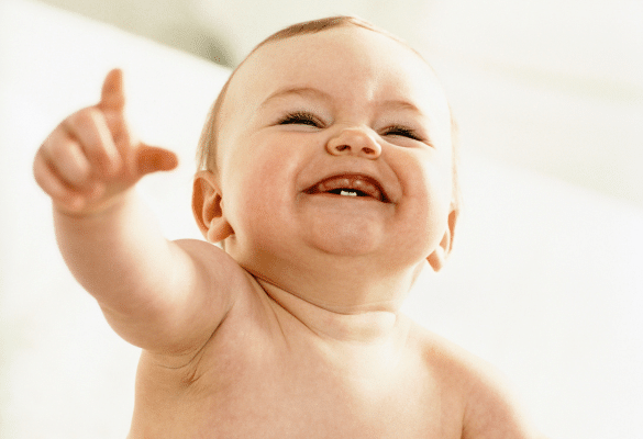 Bébé pointant du doigt vers un objet situé hors champ