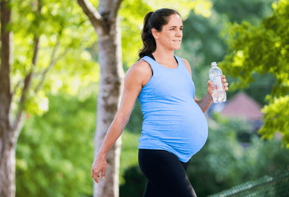 Femme enceinte marchant dans un parc pour entretenir son bien-être pendant la grossesse