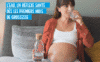 Femme enceinte buvant un verre d’eau pour illustrer le rôle de l’eau pendant la grossesse