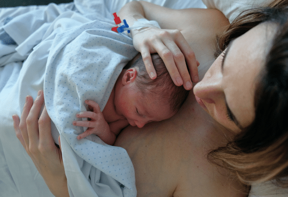 Sage-femme accompagnant une maman en travail lors de l’accouchement, hypnose et respiration pour la gestion de la douleur.
