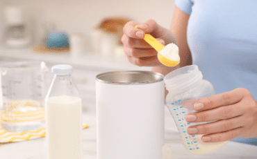 Préparation d’un biberon de lait infantile pour bébé avec poudre de lait et eau