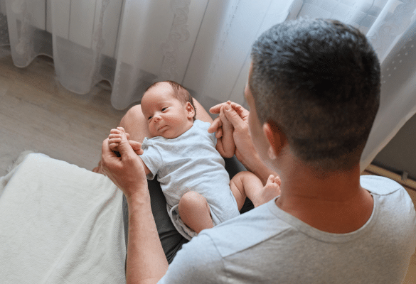 père observant son bébé pendant un moment de massage