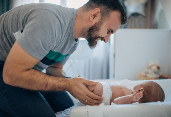 père s’occupant de son bébé sur une table à langer