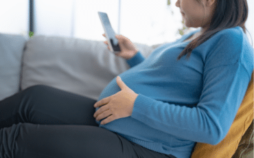 femme enceinte utilisant son téléphone pour suivre ses contractions en fin de grossesse
