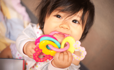 Bébé mordillant un anneau de dentition pour soulager une poussée dentaire