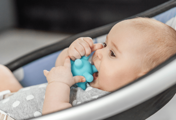 Bébé mordillant un jouet pour soulager ses gencives pendant une poussée dentaire