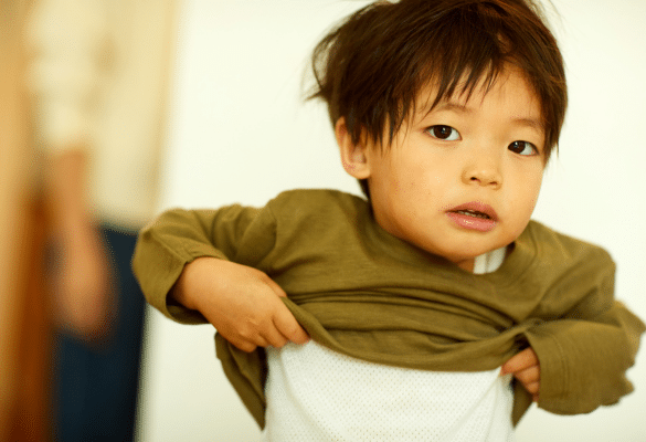 enfant qui s’habille seul pour développer son autonomie