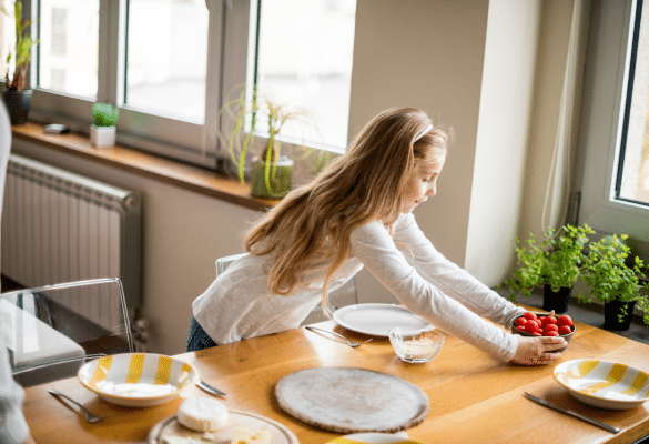 Enfant qui met la table pour développer son autonomie et son sens des responsabilités