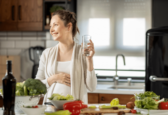 Femme enceinte préparant un repas équilibré dans sa cuisine.