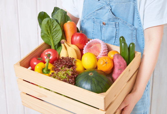 Femme enceinte tenant un panier de fruits et légumes frais