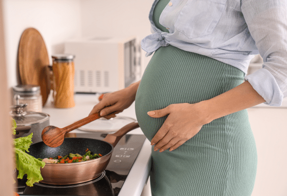 Femme enceinte préparant un repas équilibré dans sa cuisine