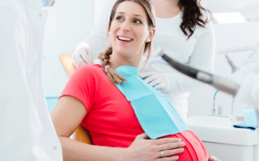 Femme enceinte en consultation chez un dentiste pour une dent de sagesse douloureuse