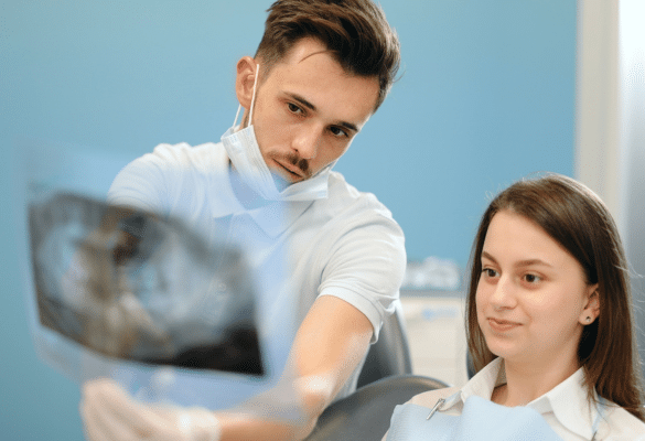 Dentiste analysant une radiographie dentaire avec sa patiente