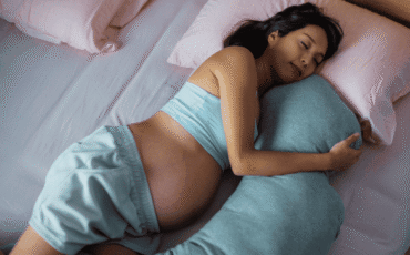 Femme enceinte dormant sur le côté avec un coussin de grossesse